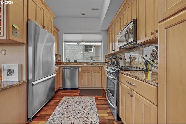 kitchen with a sink, visible vents, appliances with stainless steel finishes, and light brown cabinetry