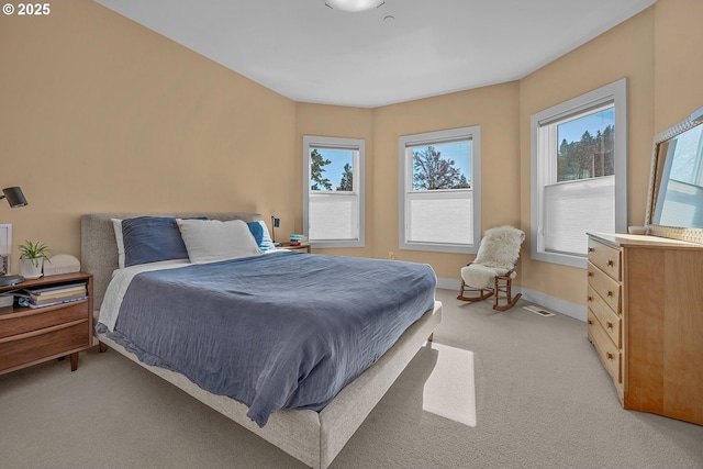 bedroom with light colored carpet and baseboards