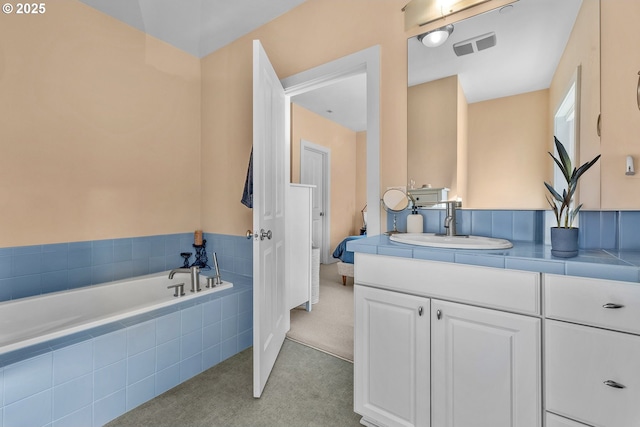 full bath with vanity, a bath, and visible vents