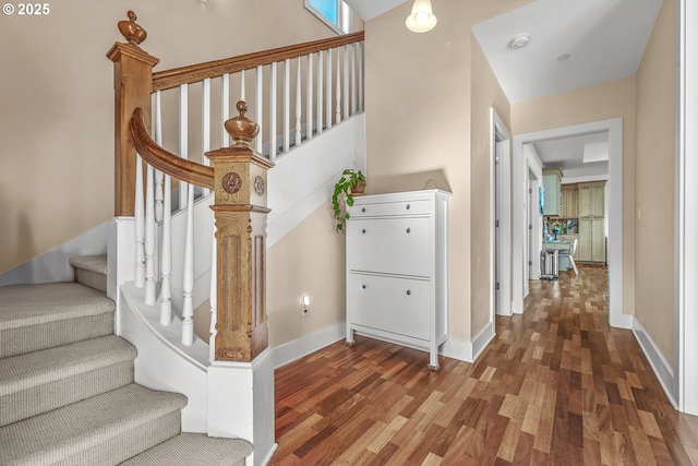 staircase featuring wood finished floors and baseboards