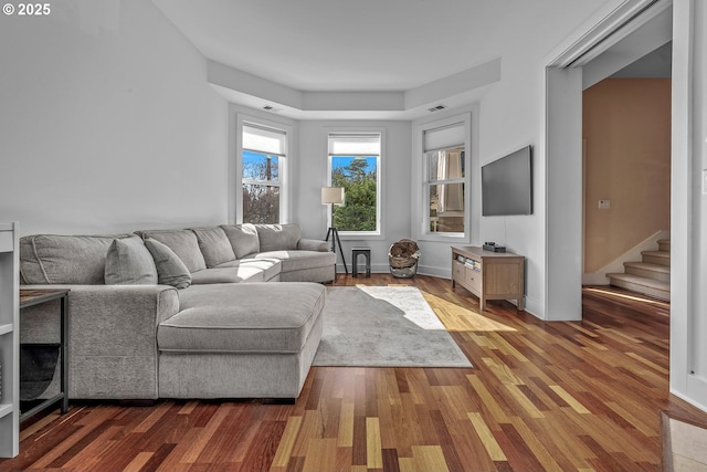 living area featuring wood finished floors, visible vents, and baseboards