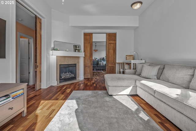 living area with a tiled fireplace and wood finished floors