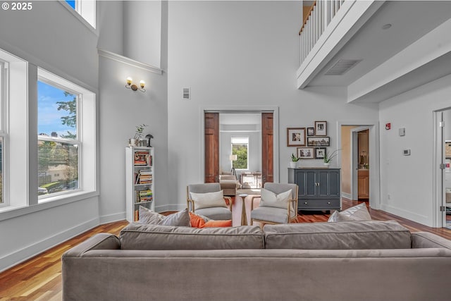 living area featuring wood finished floors, visible vents, and baseboards