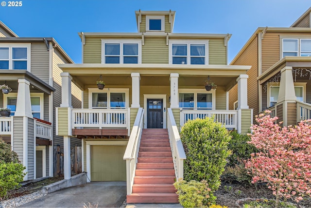 view of front of home with covered porch, asphalt driveway, a garage, and stairway