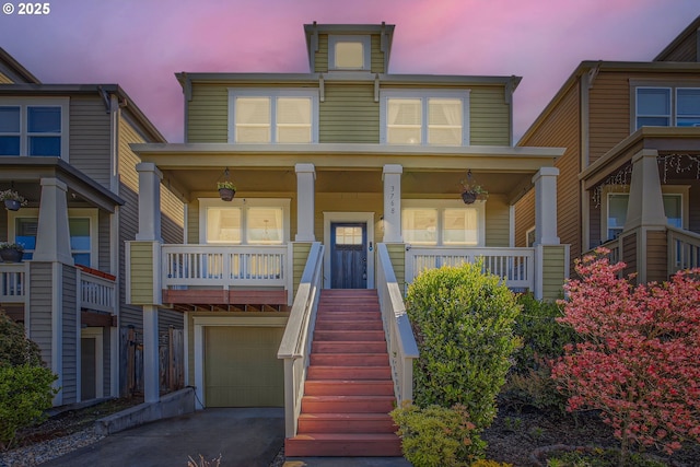 view of front of house with driveway, a porch, an attached garage, and stairway