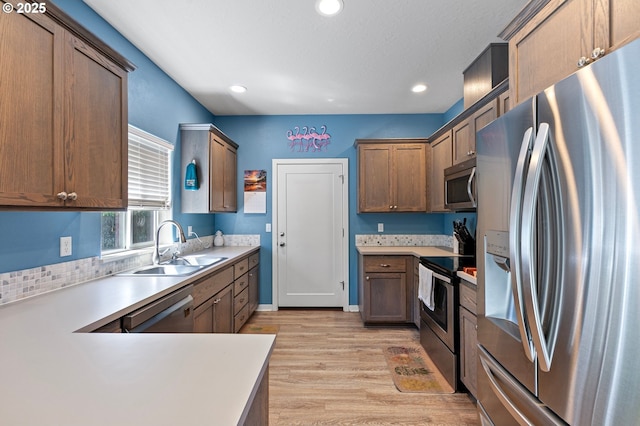 25092 Amber Ct, Veneta, OR 97487 - kitchen featuring appliances with stainless steel finishes, a sink, light wood-style flooring, light countertops, and recessed lighting