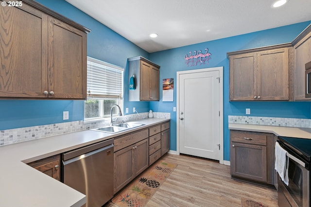 25092 Amber Ct, Veneta, OR 97487 - kitchen featuring stainless steel dishwasher, a sink, range with electric cooktop, light wood-type flooring, and light countertops