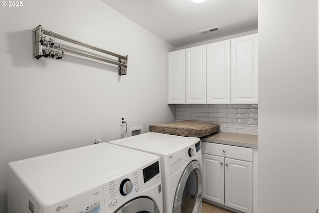 laundry room featuring cabinets and washing machine and clothes dryer