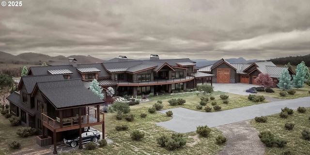 exterior space featuring a standing seam roof, metal roof, a chimney, driveway, and a deck