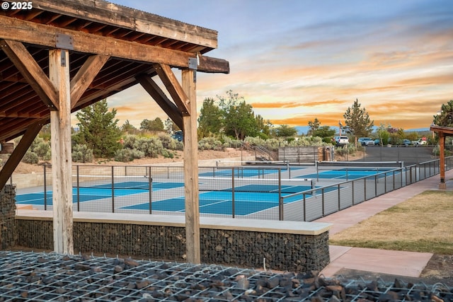 view of swimming pool featuring a tennis court and fence