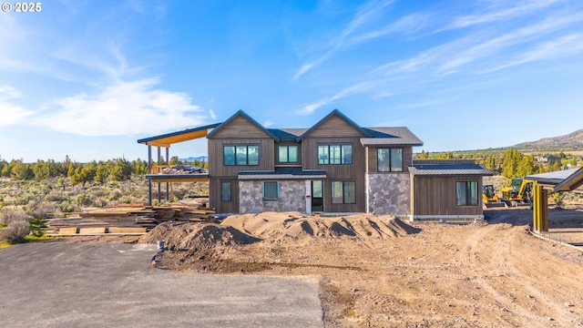 17097 SW Lago Vista Dr, Powell Butte, OR 97753 - rear view of property featuring stone siding, metal roof, a standing seam roof, and a mountain view