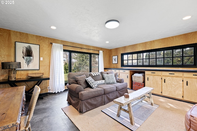 living room featuring wooden walls and recessed lighting