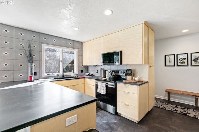 kitchen featuring dark countertops, appliances with stainless steel finishes, concrete flooring, light brown cabinets, and a sink