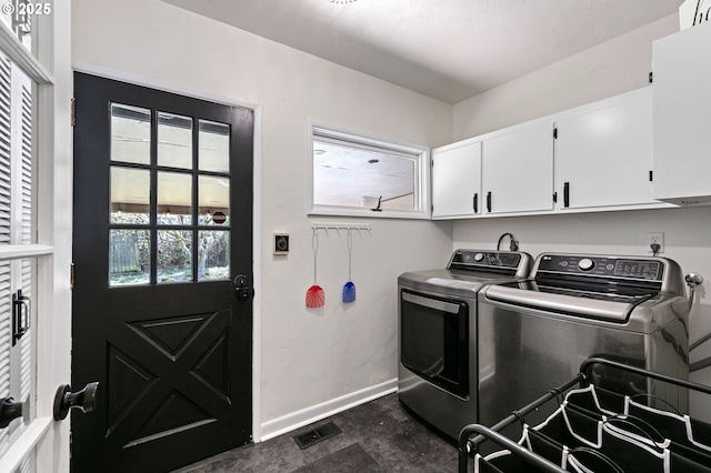 laundry area featuring washer and dryer, cabinet space, visible vents, and baseboards