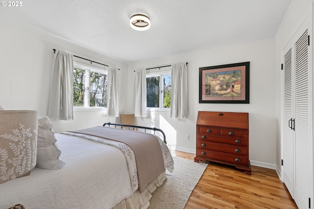 bedroom featuring baseboards, a closet, and light wood-style floors