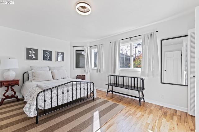 bedroom with light wood finished floors and baseboards