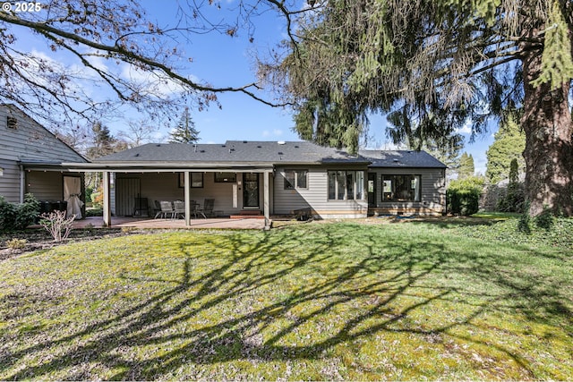 rear view of house featuring a yard and a patio