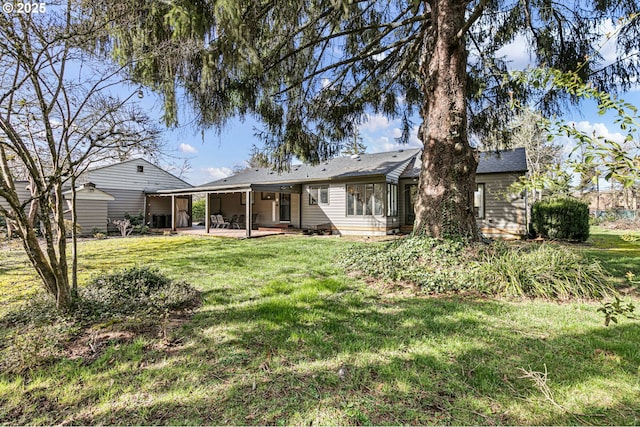 rear view of property with a patio area and a lawn