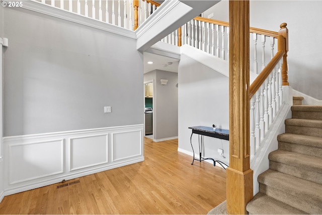 3303 NE 141st St, Vancouver, WA 98686 - stairs featuring wood finished floors, a wainscoted wall, a high ceiling, and baseboards
