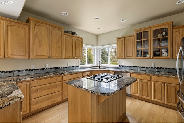 3303 NE 141st St, Vancouver, WA 98686 - kitchen with dark stone countertops, light wood-type flooring, glass insert cabinets, a kitchen island, and recessed lighting