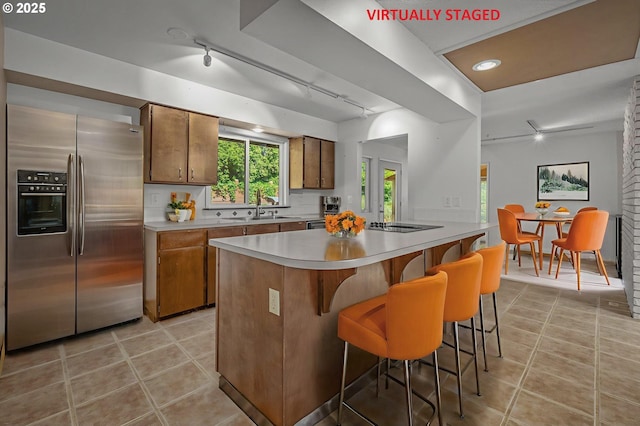 32813 NW Peak Rd, Scappoose, OR 97056 - kitchen featuring stainless steel fridge with ice dispenser, track lighting, brown cabinetry, and light countertops