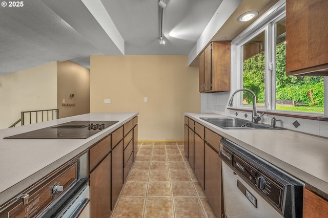 32813 NW Peak Rd, Scappoose, OR 97056 - kitchen featuring black electric stovetop, dishwashing machine, a sink, track lighting, and light tile patterned floors
