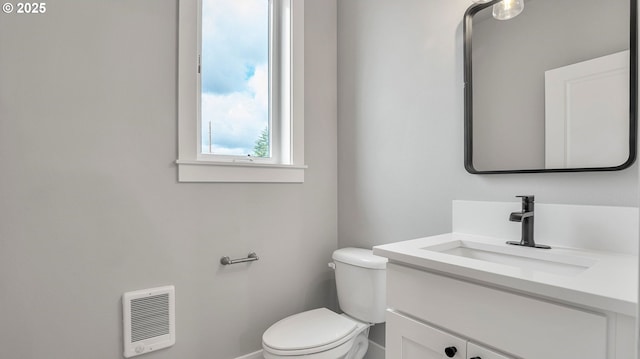 bathroom with heating unit, vanity, and toilet