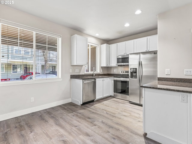 kitchen featuring white cabinetry, sink, light hardwood / wood-style flooring, and stainless steel appliances