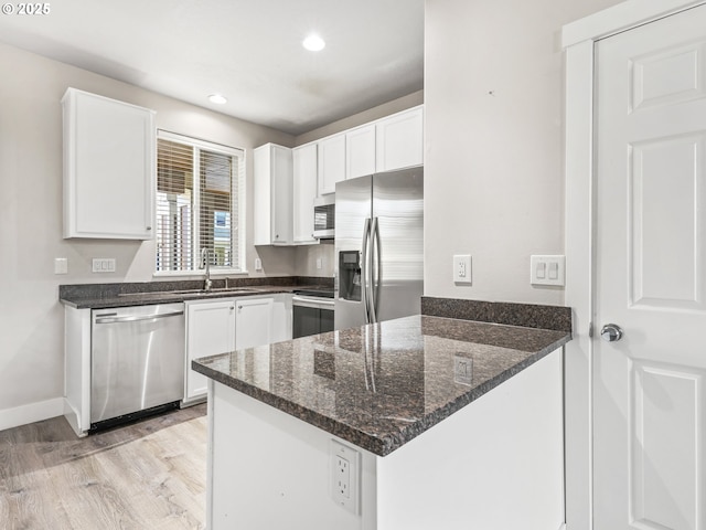 kitchen featuring white cabinetry, sink, stainless steel appliances, and kitchen peninsula