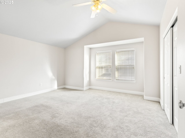 unfurnished bedroom featuring ceiling fan, lofted ceiling, light colored carpet, and a closet