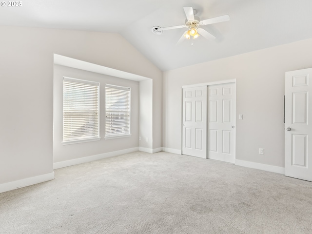 unfurnished bedroom with vaulted ceiling, light carpet, ceiling fan, and a closet