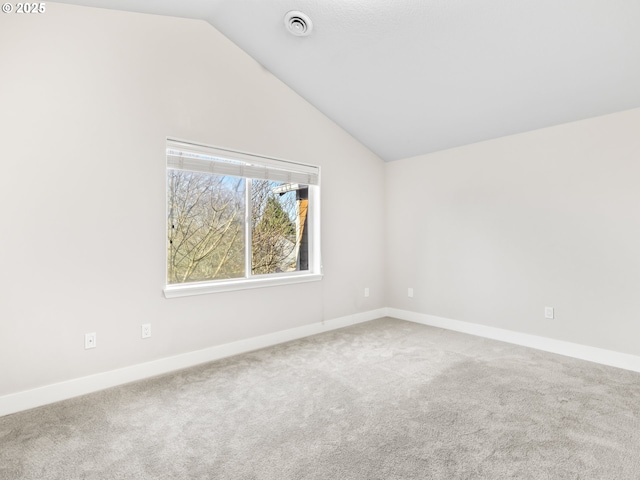 carpeted empty room with vaulted ceiling