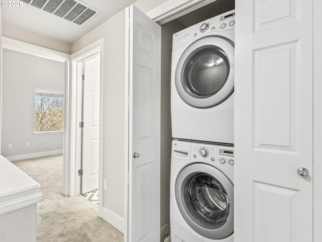 laundry room with stacked washer / dryer and light colored carpet