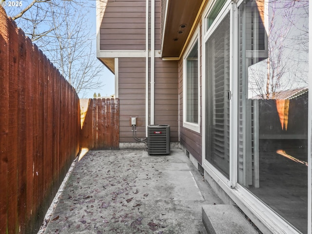 view of side of property featuring central AC unit and a patio area