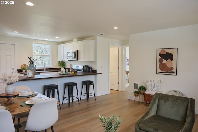 46412 Lyons Mill City Dr, Lyons, OR 97358 - interior space featuring light wood-type flooring, stainless steel microwave, white cabinetry, stove, and recessed lighting