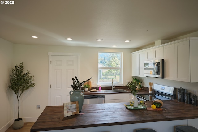 46412 Lyons Mill City Dr, Lyons, OR 97358 - kitchen with white cabinets, a sink, stainless steel appliances, and wooden counters