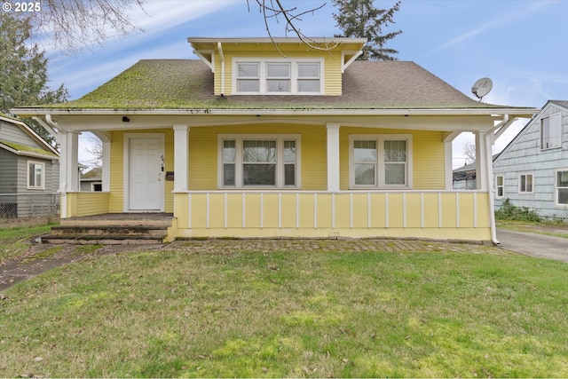 bungalow-style house featuring covered porch and a front yard