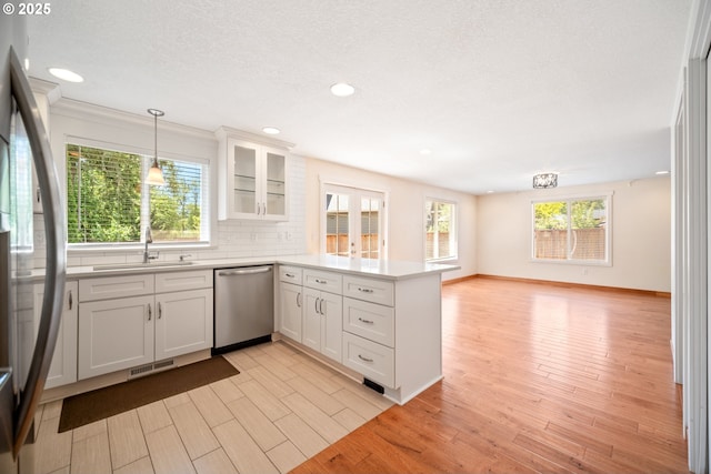 1602 NE 16th Ct, Battle Ground, WA 98604 - kitchen with stainless steel appliances, a peninsula, a sink, white cabinetry, and decorative backsplash