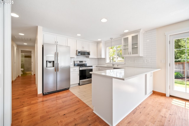 1602 NE 16th Ct, Battle Ground, WA 98604 - kitchen with appliances with stainless steel finishes, a peninsula, white cabinetry, decorative backsplash, and recessed lighting