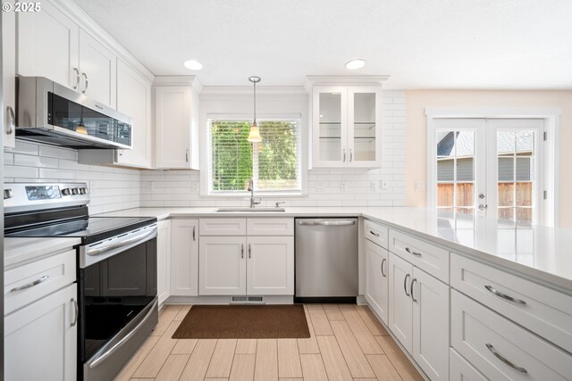 1602 NE 16th Ct, Battle Ground, WA 98604 - kitchen with stainless steel appliances, a sink, white cabinetry, light countertops, and backsplash