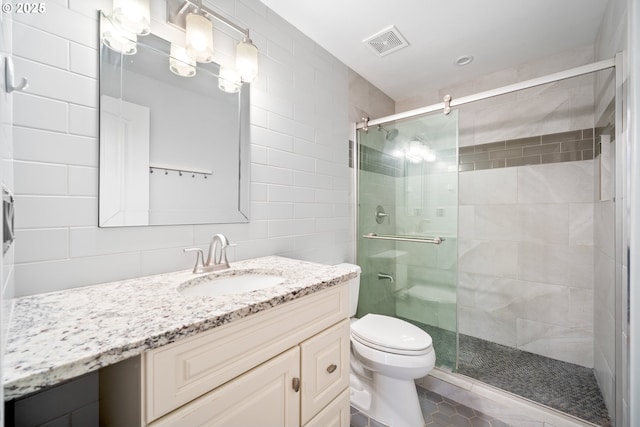 1602 NE 16th Ct, Battle Ground, WA 98604 - bathroom featuring vanity, a shower stall, toilet, tile walls, and tile patterned flooring