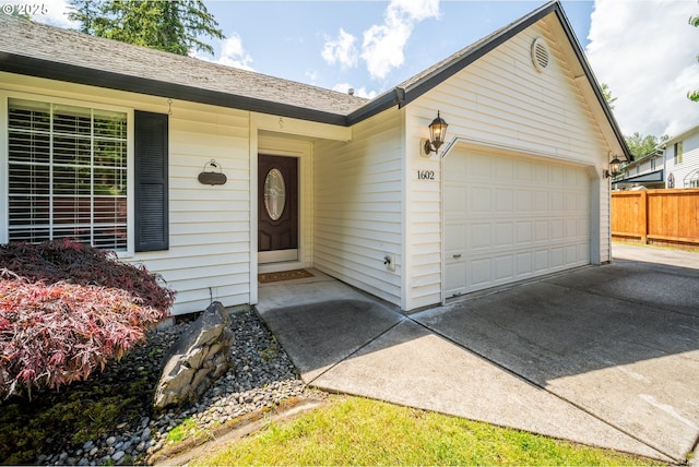 1602 NE 16th Ct, Battle Ground, WA 98604 - view of exterior entry featuring an attached garage, concrete driveway, and a shingled roof