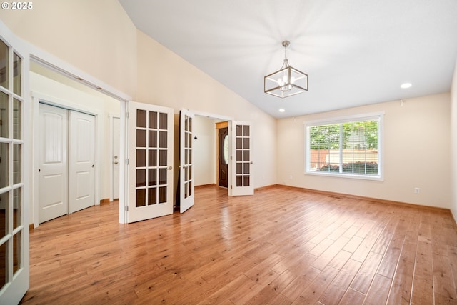 1602 NE 16th Ct, Battle Ground, WA 98604 - spare room featuring french doors, vaulted ceiling, a chandelier, light wood-style flooring, and baseboards