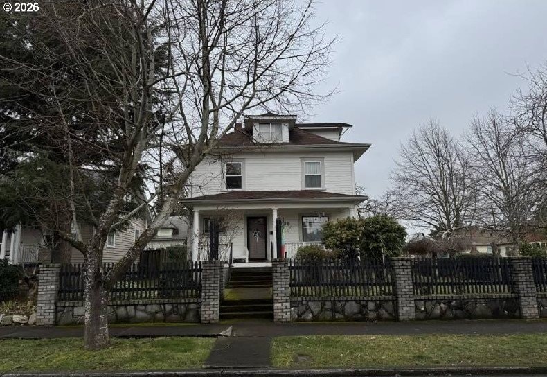 traditional style home featuring a gate, covered porch, and a fenced front yard