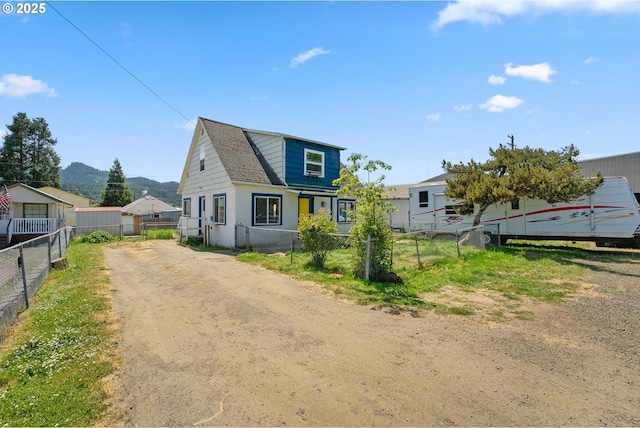 180 W Second Ave, Sutherlin, OR 97479 - view of front facade with fence, dirt driveway, and a mountain view