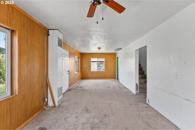180 W Second Ave, Sutherlin, OR 97479 - carpeted spare room with a heating unit, wood walls, ceiling fan, stairway, and baseboards