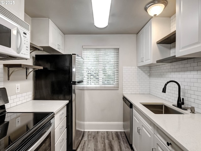 12642 NW Barnes Rd Unit 10, Portland, OR 97229 - kitchen with stainless steel appliances, wood finished floors, white cabinets, and backsplash