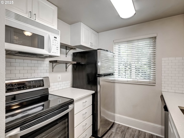 12642 NW Barnes Rd Unit 10, Portland, OR 97229 - kitchen with appliances with stainless steel finishes, decorative backsplash, dark wood-style flooring, white cabinets, and light countertops