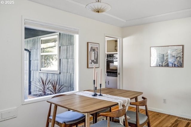 dining area featuring visible vents, baseboards, and light wood-style floors