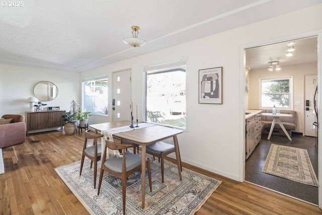 dining space featuring baseboards and wood finished floors